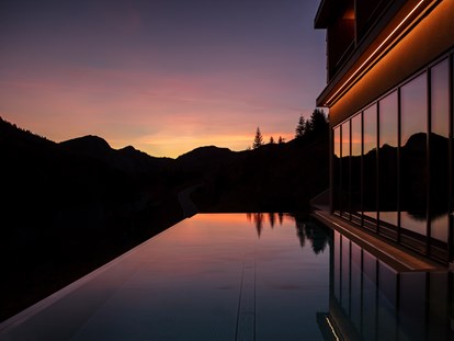Wellnessurlaub - Textilsauna - Österreich - Infinitypool im Sonnenuntergang - Alpenstern Panoramahotel