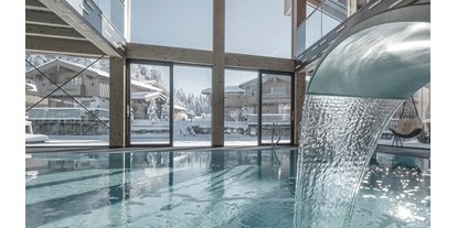Wellnessurlaub - Oberösterreich - INNs HOLZ Ausblick vom Indoorpool auf das Chaletdorf im Winter - INNs HOLZ Chaletdorf