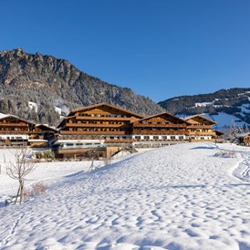 Wellnesshotel: Winterliche Südansicht des Hotels mit Bergen im Hintergrund - Alpbacherhof****s - Mountain & Spa Resort