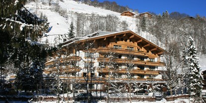Wellnessurlaub - Hotel-Schwerpunkt: Wellness & Skifahren - Kitzbühel - Winter Hausansicht Vorderseite - Gartenhotel Theresia****S - das "grüne", authentische Hotel.