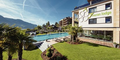 Wellnessurlaub - Pools: Infinity Pool - St. Martin (Trentino-Südtirol) - Die Meran Lodge, die Liegewiese, der Infinitypool und das La Maiena Stammhaus. - La Maiena Meran Resort