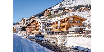 Wellnessurlaub - Rücken-Nacken-Massage - Davos Dorf - Aussenansicht Hotel Auenhof in Lech im Winter - Hotel Auenhof