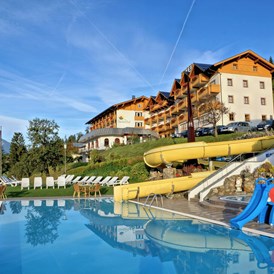 Wellnesshotel: Freibad mit Wasserrutsche und Liegewiese - Hotel Glocknerhof